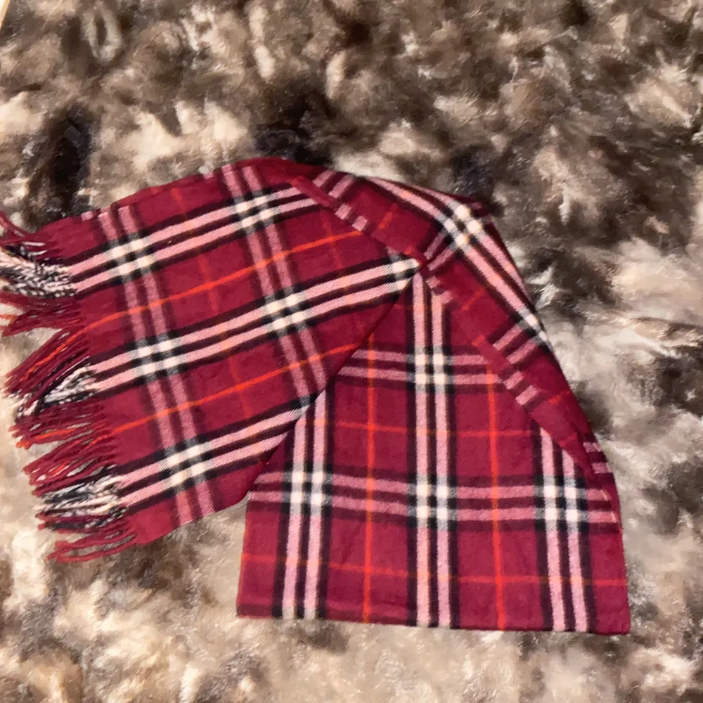 Aldrig använd burberry halsduk i Kashmir. Inga skador och väldigt bra skick. Färgerna röd & svart. Denna modell säljs ej längre. Pris kan diskuteras!. Accessoarer.