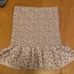 Lila blommig kjol - Vit kjol med lila blommor, resår över hela förutom längst ner