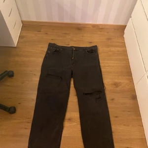 Svarta raka jeans med hål - Vanliga svarta jeans med hål de är raka i benen. Har används flertals gånger men inget fel eller missfärgningar/tappat färg. Använder inte längre så därför jag säljer de. De har knappar ist för gylf