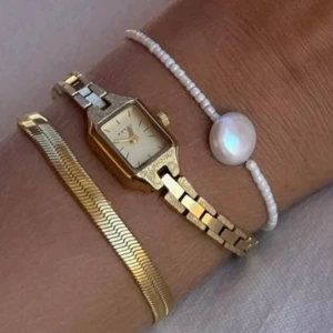 Bovou klocka - Säljer en klocka i guld från Bovou, inga defekter och batterier funkar🩵 Man kan också köpa pärlarmband på första bilden 