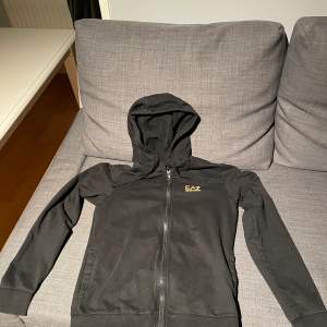 Det är en zip upp hoddie från EA7 och är i storleken XS och skicket är bra