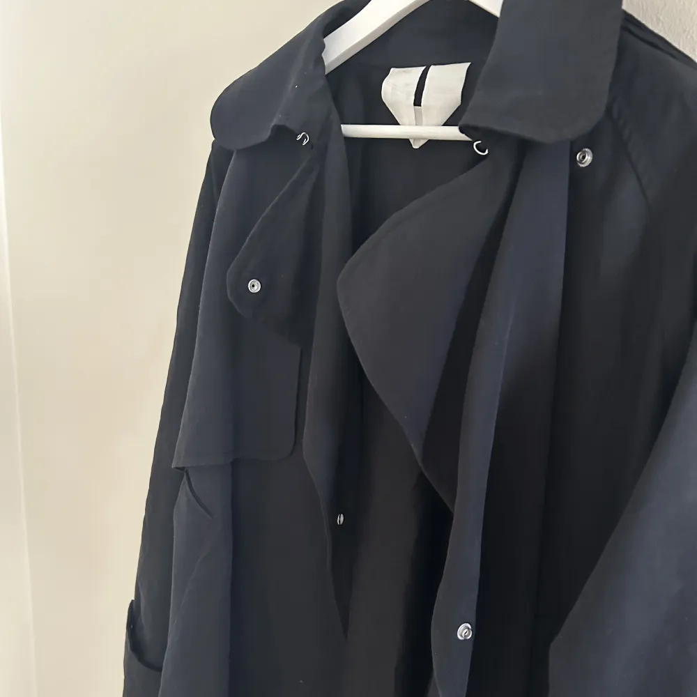 Säljer en svart kort trenchcoat från Arket. Använd ett par gånger och har inga defekter. Trenchcoaten är slut på hemsidan och nypriset är 1750 kr. . Jackor.