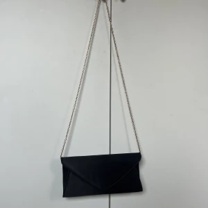 Liten handväska  - Liten handväska från Anne Field. Använd endast en gång. Nypris 300kr. Kan användas både som kuvertväska eller med bandet. 