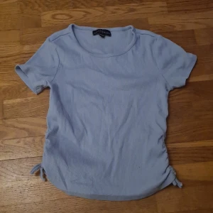 T-shirt med dragsko på sidorna - Ljusblå tshirt med dragsko på sidorna