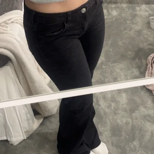 Svarta lågmidjade jeans  - Säljer mina svarta lågmidjade bootcut jeans. Super snygga och sköna men andbänds aldrig💕 Har en lite klorin fläck längst ner och sedan pytte lite slitna också då de varit förlånha men detta är inget man ser när man har de på sig (se sista bild)🙏🏼💕