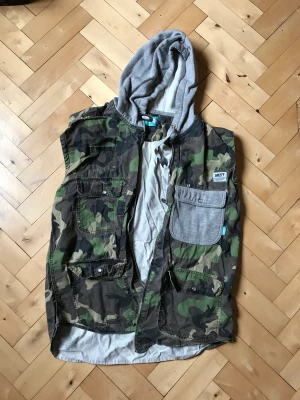 Sweet väst  - Tunn väst från Sweet, camo-mönster med mjukisluva. Använt men fint skick. 