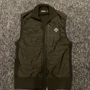 J.Lindberg väst - Riktigt skön väst speciellt med en skön hoodie under, men funkar väldigt bra med en vanlig tröja också. Skick=9/10, storlek S men funkar mycket bra till folk med M, märke J.Lindberg, färg svart, modellen är 187cm och väger 78kg, ny pris 2400