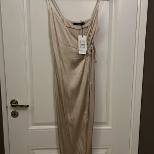 Siden klänning  - Champagne färgade siden klänning från Bikbok. Oanvänd. Nypris 499kr. Lapp finns kvar. Köpare står för frakten. 
