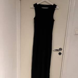 Superlång svart klänning med hög nacke, har även en liten slits på vänstra sidan. Använd 2 gånger 