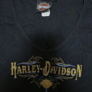 T-shirt - Super fin Harley Davidson t-shirt med ”slit” på axlarna. Står ingen storlek men passar bra på mig som oftast har S, kan tänka mig att den även passar M💗