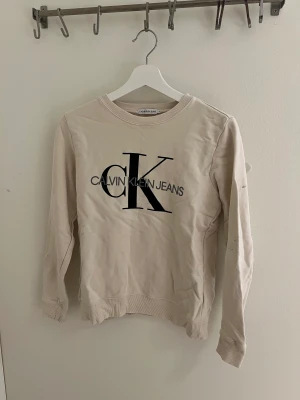 calvin klein tröja - fin tröja från calvin klein. Strl M. Finns några fläckar, se bild.😊 Beige/Vit/Rosa