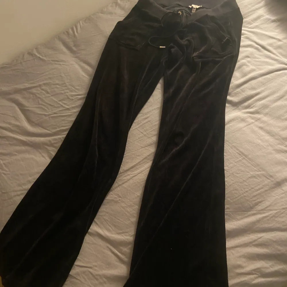 Svarta juicy couture byxor i en äldre modell. Dem är lågmidjade och i storlek small. Defekt på knapparna där bak då lite av den silvriga färgen försvunnit, annars bra skick. . Jeans & Byxor.