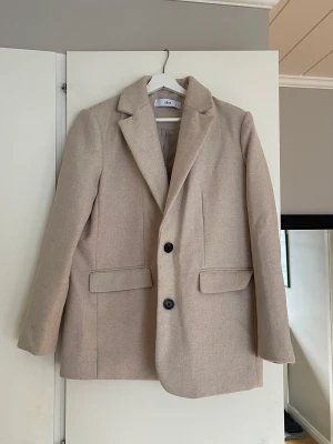 Beige kavaj - Beige kavaj i ett tjockare material från Ellos, använd fåtal gånger. 