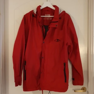 Vind- och regnjacka  - Röd vind- och regnjacka.  Ross skiwear. Storlek S. 