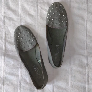 Gröna loafers/flats/lågskor/ballerinaskor/tygskor - storlek 39 - Gröna loafers i tyg med silverfärgade nitar. Bara använda ett par gånger. Lite missfärgningar invändigt och ett litet hål undertill i hälen. Storlek 39.