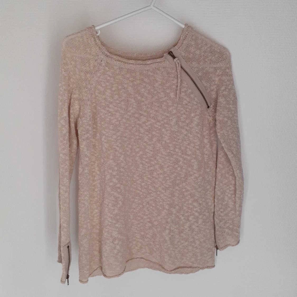 Beige Kofta med schyssta dragkedjedetaljer.