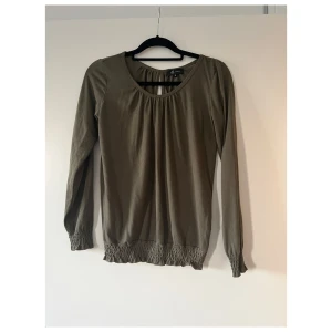 Khaki grön blus - Enkel, kvinnlig khaki grön top med långa ärmar. Kommer från YFL Reserved. Mycket bra skick. 