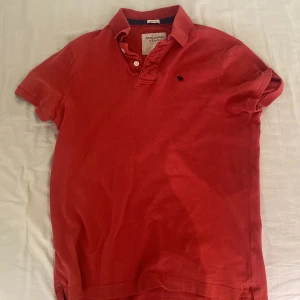 Pikétröja - Röd pikétröja. Det står xl men Jag är 186 80 kg och tröjan sitter bra på mig. 