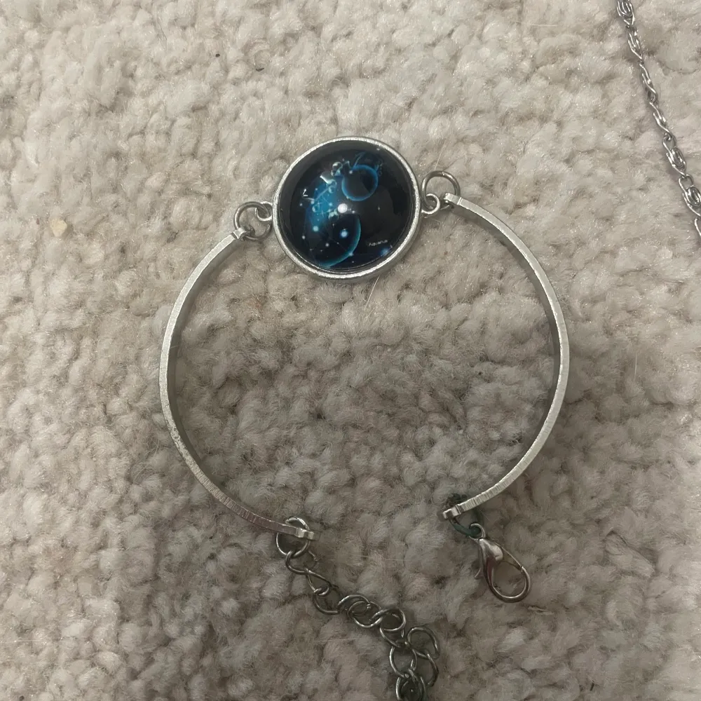 Ett armband med en bild som är blå planeter, och ett halsband med en måne också. Väldigt fina 🌙🌑. Accessoarer.