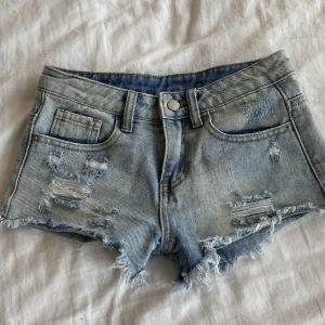 Lågmidjade jeansshorts! - Säljer nu dessa as snygga Lågmidjade jeansshorts i en ljusblå färg! Så coola med slitningar också! Vet ej storlek då lappen är borta men skulle säga runt xs passar även xxs!🤩🤩