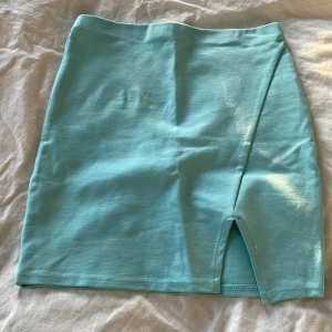 Tight kort kjol med slits, turkos - Köpt i USA, aldrig använd. Ska vara stl S men är mer som en Xs