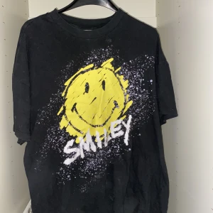 Svart T-shirt  - En svart T-shirt men ett stort tryck på framsidan! Den är i ganska bra skick! Sitter ganska oversised