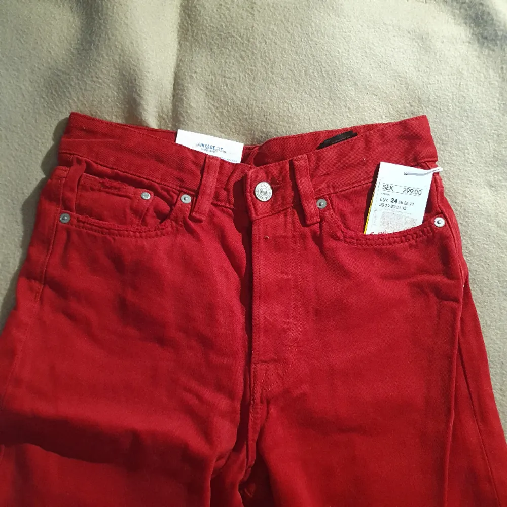 Oanvända Röda vintage high cropped jeans från H&M. Hög midja. 5 fickor och knappgylf! Coolt slitna vid fickor. (köpte helt fel storlek & glömde returnera hehe) Nypris 299kr. Jeans & Byxor.