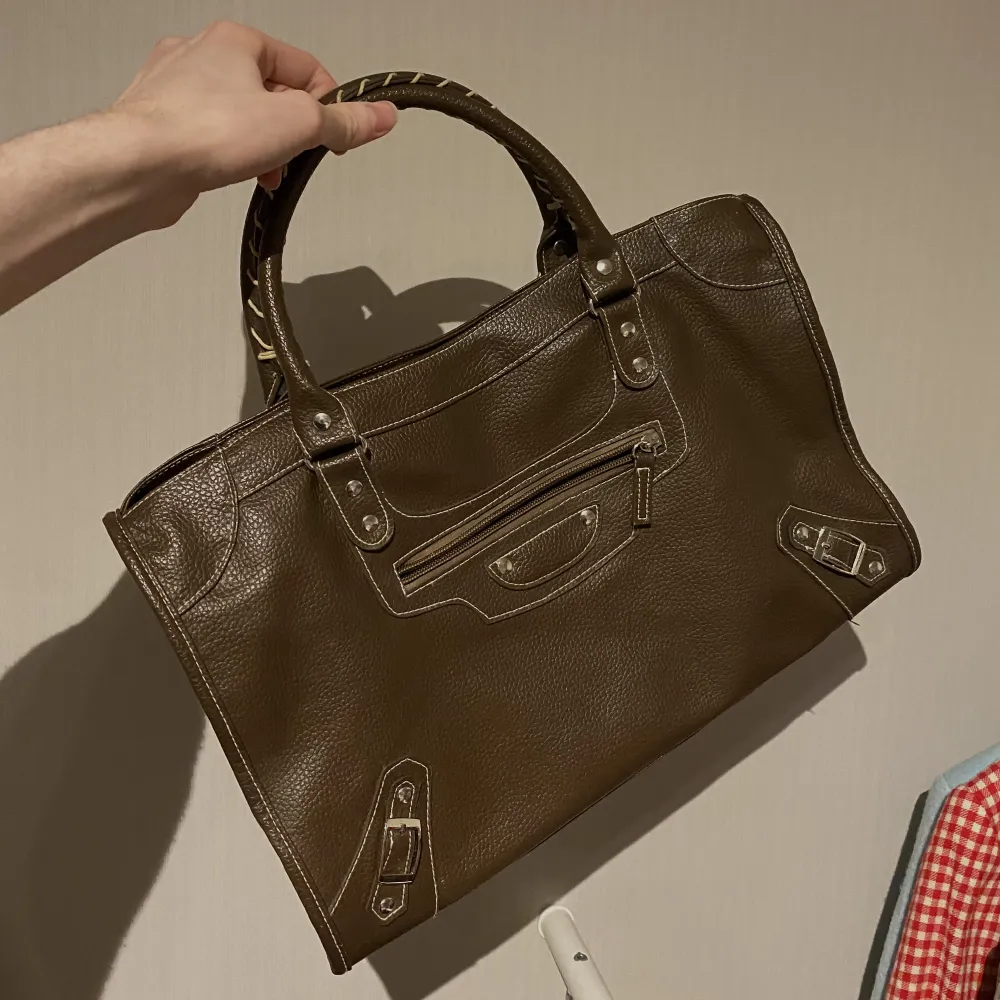 Säljer denna ursnygga Balenciaga inspererade citybag, är i brunt läder med nylon på insidan, har en liten skråma på baksidan men annars i fint skick. Är rymlig så du får både plats med dator och necessär🤎🤍. Väskor.