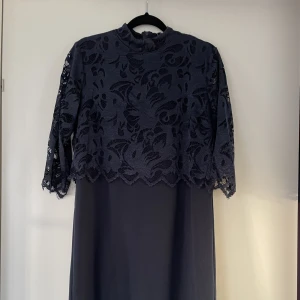 Marinblå klassisk klänning från Boozt - Snygg och skön klassisk klänning från Freequent. Köpt på Boozt. Ser tvådelad ut, men är en klänning. Dragkedja i ryggen. XS, men passar även S/M Nypris: 500kr