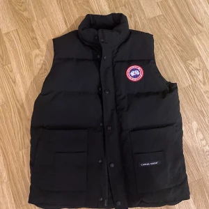 Canada Goose väst - Säljer canada Goose väst som är i väldigt bra skick och knappt använd. Den är i storlek M. Äkta såklart och köpt på länna sport. Nypris är ca 4500kr