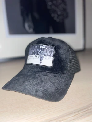 Velvet keps ”STAMKOS” - Trycket ”STAMKOS” är taget 2021 när NHL-laget Tampa Bay lightning vinner Stanley Cup. Kanadensaren Steven Stamkos lyfter upp pokalen i bilden, och denna keps är för dig som ÄLSKAR ishockey!   Material: Velvet  Färg: Svart.    OBS!! BEGRÄNSAT ANTAL✅