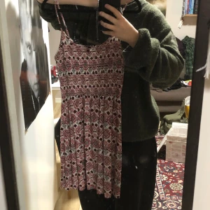 Mönstrad klänning - Röd och vit mönstrad klänning med stretchig överdel, ganska kort. Passar S-M men blir nog lite kort på större storlekar