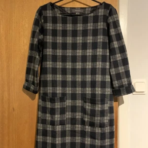 Klänning - Klänning från Primark med två fickor framtill, bra skick då den knappt är använd. Mörkgrå med svartblåa rutor. 