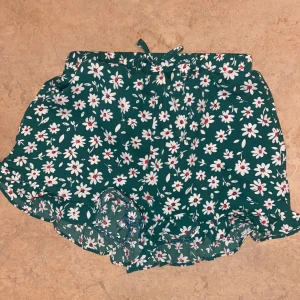 Shorts - Ett par gröna mjukis shorts med vita blommor