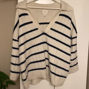 H&m stickad tröja - Säljer den här stickade tröjan från h&m i storlek M. Den är blå/vit randig och är jätteskön o mjuk. Den är lite kortare i armarna (trekvartslånga). Har knappt använts men som man ser på bilden är den nopprig.