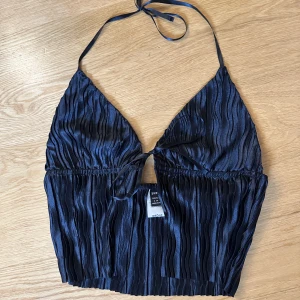 Topp - Säljer en svart topp med knyte då den inte kommer till användning