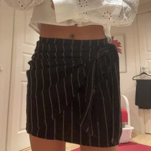 Kjol - Kjol från hm med knytning i svart med guldiga små ränder❤️