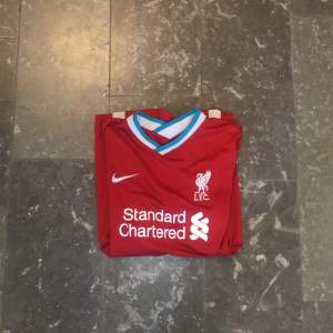 Säljer denna Liverpool Hemma tröja som nu blivit för liten. Köpte den i början utav 20/21 säsongen och är inga fel på. Tröjan sitter stort och om ni har några frågor eller funderingar är det bara att höra av sig👊🏻