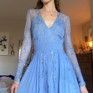 Blå balklänning - Superfin ljusblå maxiklänning med långa mesh-ärmar och broderade blommor. Endast använd en gång😊