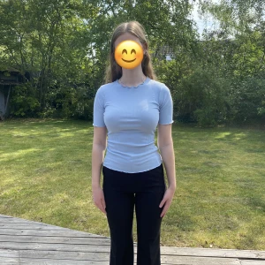 Blå topp - Ljusblå topp, lite randigt i tyget med detaljer vid halsring, ärmar och nertill, ursprungligen från NAKD