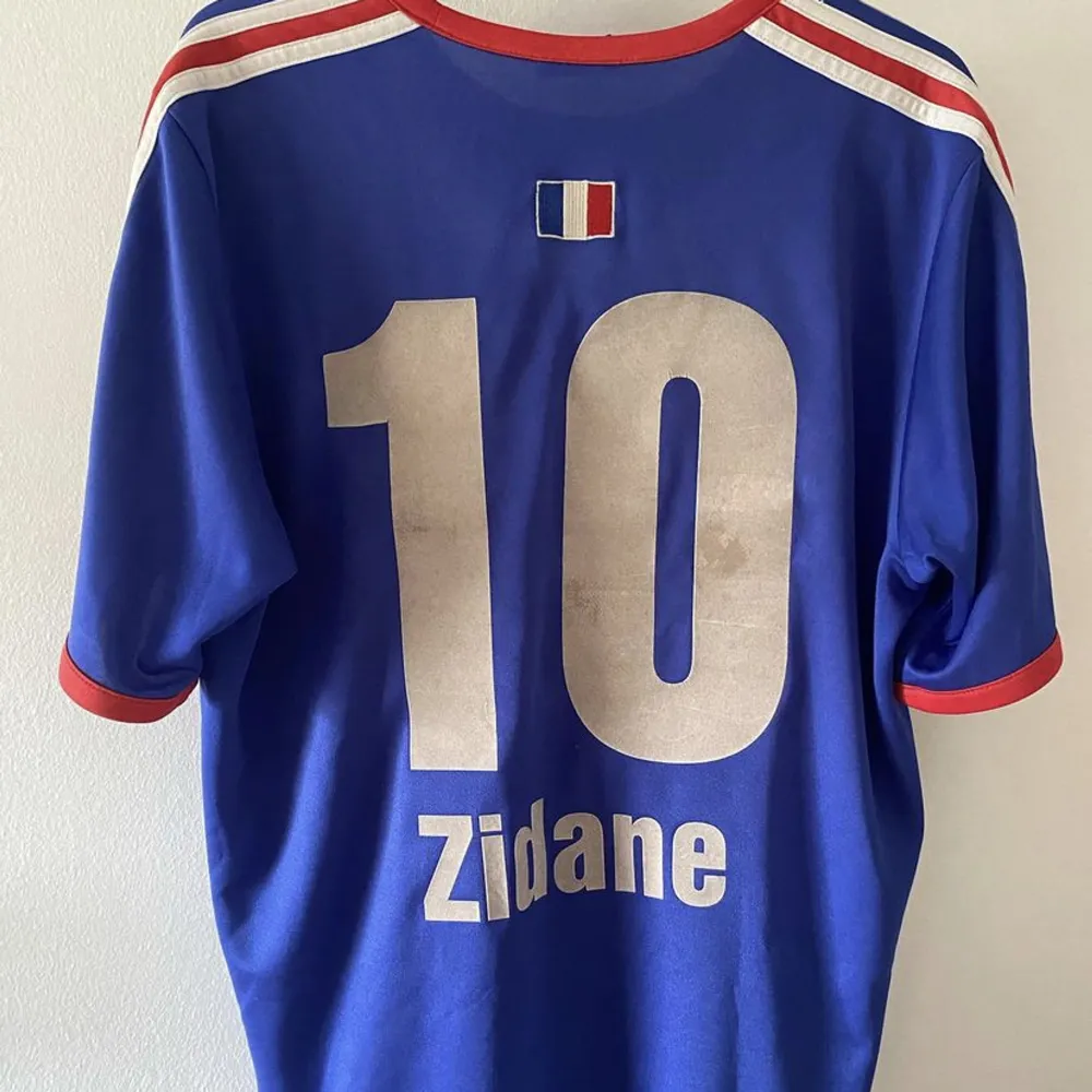 Frankrike träningströja 2004 med Zidane på ryggen. Självklart äkta. 8/10 skick, väldigt bra för åldern. Väldigt unik tröja till en samling! Kolla även in mina andra tröjor, kan få paketpris! Skriv för frågor eller mer bilder! . T-shirts.