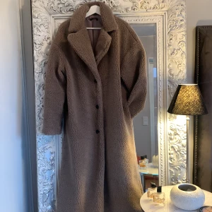 Teddy kappa - Beige nougat kaffelatte färgad lång Teddykappa. Finare i verkligheten än på bild. Som ny, knappt använd. Mjuk och behaglig.