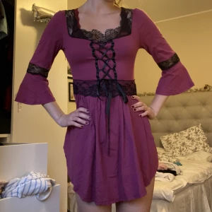 Klänning  - Plommonfärgad klänning med svart spets och glansiga band. Knytning framtill och ganska kort. 🌹