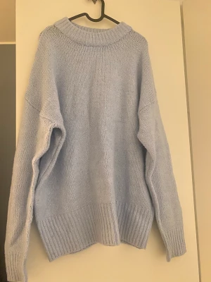 Snygg blå stickad tröja - Fin ljusblå stickad tröja från Lager157. Har använt en gång och köptes för lite mer än ett år sedan. Tröjan är inte stickig alls. Jag har vanligtvis storlek S i kläder men tog denna i M och är super cute som lite oversize.
