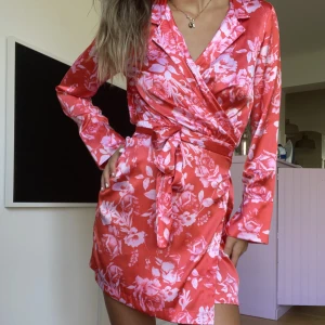 Blommig klänning - Blommig klänning i satin liknande material. 