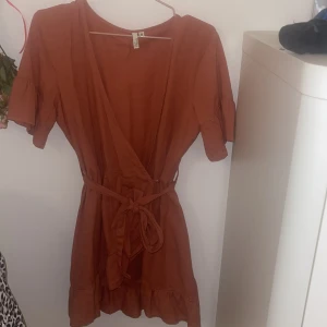 Omlottklänning med volange  - Fin omlottklänning med volanger nertill 