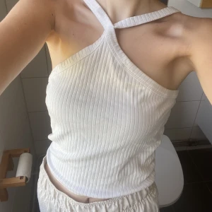 Vit korsad ribbad topp - Vit topp med korsning och även ribbat! Jätte fint och passar till vardags eller fest! Passar till allt en fin sommardag! 