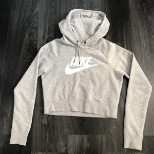 Nike Hoodie lite kortare  - En fin ljusgrå Nike Hoodie i fint skick. Inga fläckar eller andra skråmor, köpt på stadium.