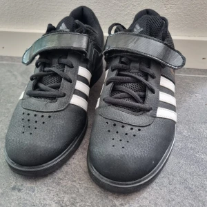 Lyftarskor - Tyngdlyftningsskor med klack från adidas. Jättefint skick, dock behöver den ena skon nytt snöre då det fastnat i kardborren.  Nypris 999kr