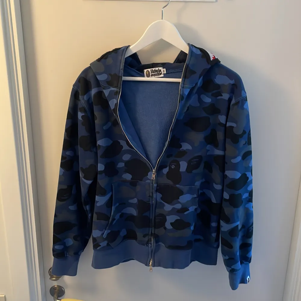 En blå Bape hoodie i storlek M. Den är jättesnygg och bra kvalitet och jag verkligen älskar den.  Men den passade inte i storleken och vara alltså för stor för mig. Därför säljer jag den här istället!💞. Hoodies.